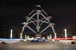 InMotion racecar in front of Atomium Brussels with light beams